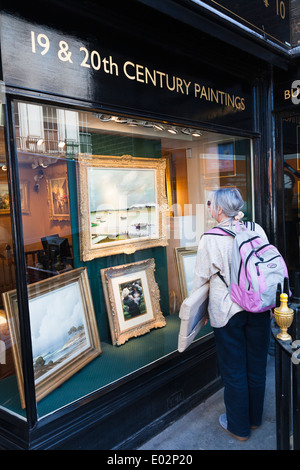 Femme transportant enveloppé à la galerie de peinture dans la fenêtre. Banque D'Images