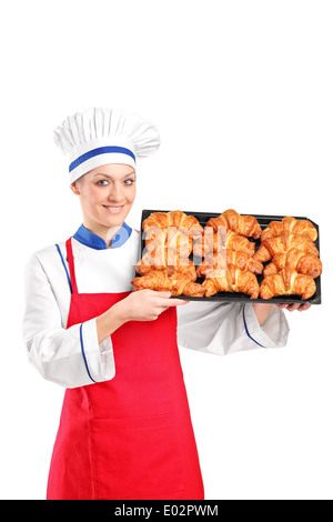 Chef pâtissier femme tenant une casserole pleine de croissants Banque D'Images