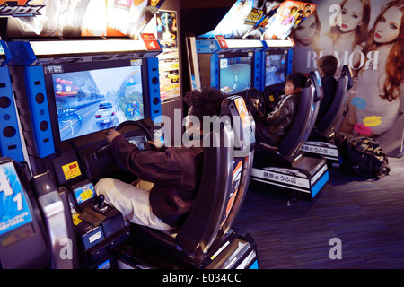 Gens jouer jeu vidéo de machines à sous dans une arcade à Tokyo, Japon Banque D'Images