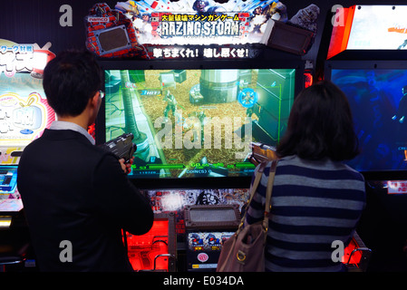 Gens jouer tir rasant Storm jeu vidéo Arcade slot machines à Tokyo, Japon Banque D'Images