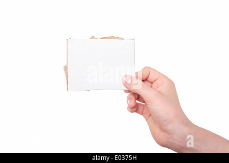 Une main tenant un morceau de carton blanc. Banque D'Images