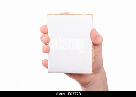 Une main tenant un morceau de carton blanc. Banque D'Images
