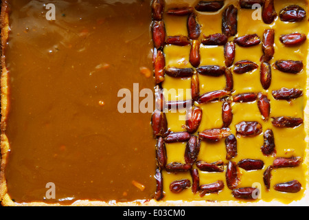 Tarte pâte brisée avec de la crème caramel et dattes séchées, cuit traditionnellement dans la Pologne pour Pâques. Vue de dessus. Banque D'Images