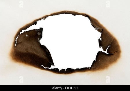 Morceau de papier brûlé avec trou dans la forme ovale avec fond blanc. Banque D'Images