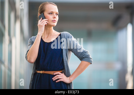 Portrait d'une jeune femme appelant sur un smartphone dans un contexte urbain/ville (shallow DOF ; couleur tonique libre) Banque D'Images