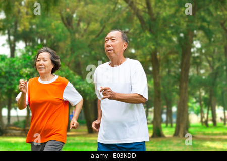 Happy senior couple fonctionnant ensemble dans le parc Banque D'Images