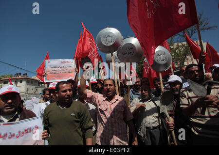 Gaza, la Palestine. 01 mai, 2014. Travaux palestinienne slogans chant comme d'autres l'attente lors d'un des bols mars pour la Journée internationale du travail dans la ville de Gaza, le Jeudi, Mai 1, 2014. L'arabe se lit, ''Le bol de la faim, la pauvreté et la famine, où est la conscience, '' Selon le Bureau des Nations Unies pour la coordination des affaires humanitaires, le taux de chômage dans la bande de Gaza est l'un des plus élevés au monde. Credit : ZUMA Press, Inc./Alamy Live News Banque D'Images