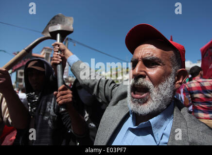 Gaza, la Palestine. 01 mai, 2014. Travaux palestinienne slogans chant comme d'autres l'attente lors d'un des bols mars pour la Journée internationale du travail dans la ville de Gaza, le Jeudi, Mai 1, 2014. L'arabe se lit, ''Le bol de la faim, la pauvreté et la famine, où est la conscience, '' Selon le Bureau des Nations Unies pour la coordination des affaires humanitaires, le taux de chômage dans la bande de Gaza est l'un des plus élevés au monde. Credit : ZUMA Press, Inc./Alamy Live News Banque D'Images