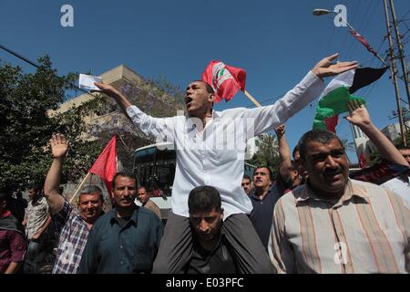 Gaza, la Palestine. 01 mai, 2014. Travaux palestinienne slogans chant comme d'autres l'attente lors d'un des bols mars pour la Journée internationale du travail dans la ville de Gaza, le Jeudi, Mai 1, 2014. L'arabe se lit, ''Le bol de la faim, la pauvreté et la famine, où est la conscience, '' Selon le Bureau des Nations Unies pour la coordination des affaires humanitaires, le taux de chômage dans la bande de Gaza est l'un des plus élevés au monde. Credit : ZUMA Press, Inc./Alamy Live News Banque D'Images