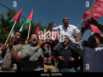 Gaza, la Palestine. 01 mai, 2014. Travaux palestinienne slogans chant comme d'autres l'attente lors d'un des bols mars pour la Journée internationale du travail dans la ville de Gaza, le Jeudi, Mai 1, 2014. L'arabe se lit, ''Le bol de la faim, la pauvreté et la famine, où est la conscience, '' Selon le Bureau des Nations Unies pour la coordination des affaires humanitaires, le taux de chômage dans la bande de Gaza est l'un des plus élevés au monde. Credit : ZUMA Press, Inc./Alamy Live News Banque D'Images