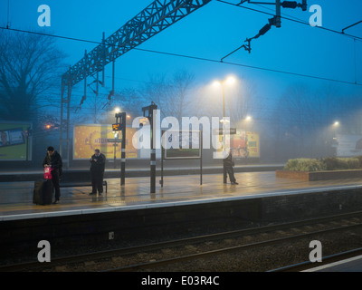 Personnes en attente d'un train sur un jour brumeux à Watford Junction railway station Banque D'Images