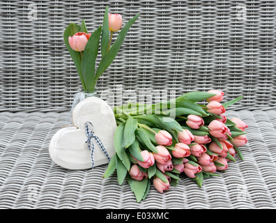 Vase avec fleurs tulipe rose et coeur de formes pour la fête des mères, sur fond de bambou Banque D'Images