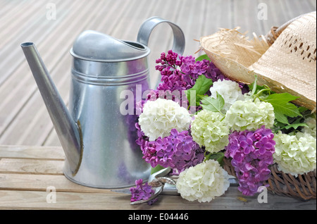 Fleurs lilas fraîchement cueilli dans un panier sur terrasse en bois Banque D'Images