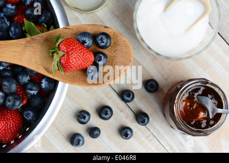 Angel haut photo d'une fraise et de bleuets sur une cuillère en bois portant à travers une passoire pleine de baies Banque D'Images