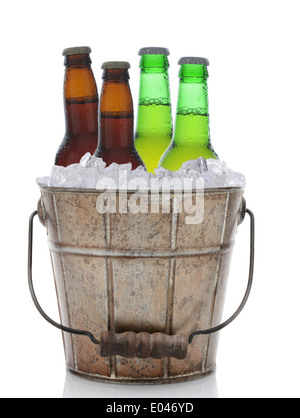 Un seau rempli de glace et les bouteilles de bière. Brun et vert quatre bouteilles de bière sont en format vertical Banque D'Images