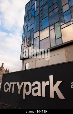 Paysage urbain close-up de grand noir argent Bradford City Park signe avec façade en verre de l'ancien poste de police, derrière - West Yorkshire, Angleterre, Royaume-Uni. Banque D'Images