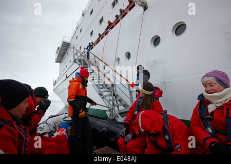 Les passagers à bord d'un zodiac au bas de l'echelle de bateau pour l'excursion dans l'antarctique Banque D'Images