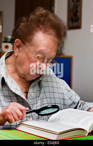 Vieille Femme à lunettes lit un livre, Alte Frau mit Brille liest ein Buch Banque D'Images