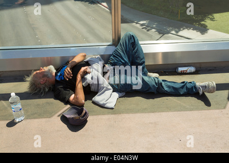 Ivre et sans-abri pose vieil homme endormi sur le plancher d'une passerelle piétonne à Las Vegas, Nevada USA Banque D'Images