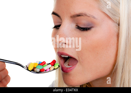 Jeune femme avec de comprimés sur : cuillère, Junge Frau mit vielen Tabletten auf Loeffel : Banque D'Images