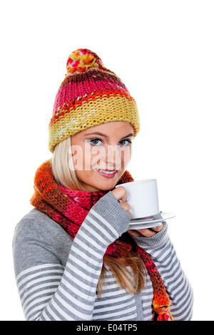 Jeune femme avec net pièce réchauffe elle-même avec du thé chaud., Junge Frau mit sich mit Haube waermt heissem Tee. Banque D'Images