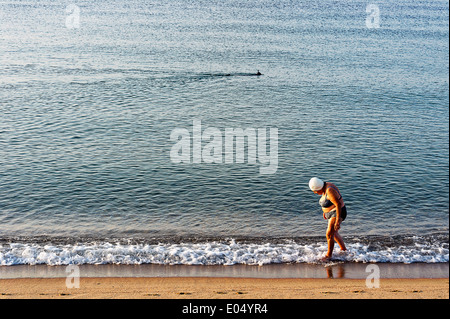 Europe, France, Alpes-Maritimes, Cannes. Vieille femme marchant dans une plage. Banque D'Images