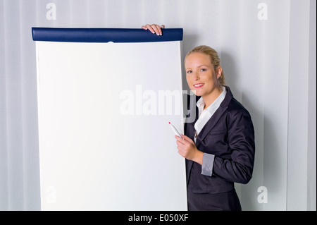 Une jeune femme avec un tableau de bord par un exposé. La formation continue et l'éducation des adultes., eine junge Frau mit einer Fli Banque D'Images