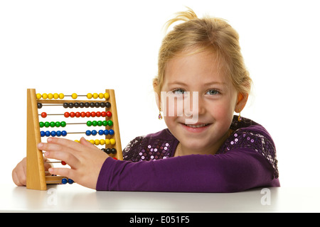 Une petite école enfant compte sur un abaque., Ein kleines Schulkind rechnet mit einem Abakus. Banque D'Images