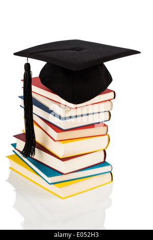 Une thèse de capuchon sur une pile de livres, photo symbolique pour l'éducation et de compétence Banque D'Images