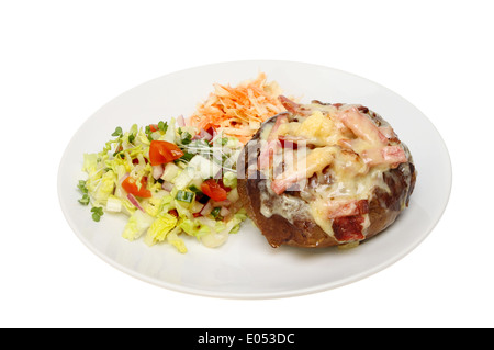 De fromage et de bacon, pomme de terre au four avec de la salade sur une assiette blanche contre isolés Banque D'Images