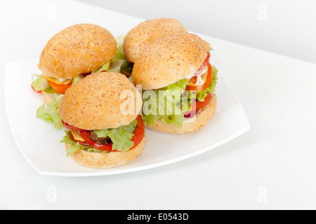 Les hamburgers faits maison déposer sur plaque blanche. Studio photo Banque D'Images