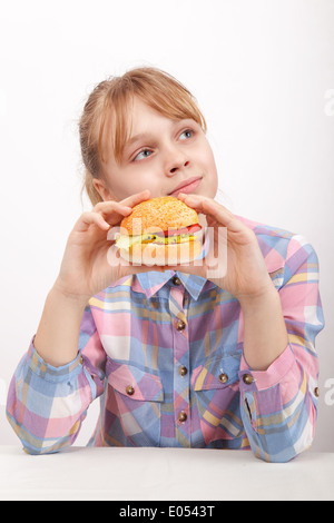 Petite fille blonde avec des hamburger sur fond blanc Banque D'Images