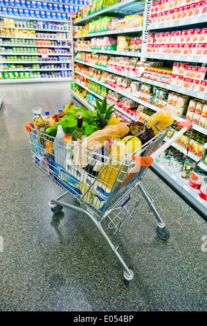 Un panier est d'une façon d'un supermarché entre les étagères., Ein Einkaufswagen steht einem von Supermarktes Gang Banque D'Images