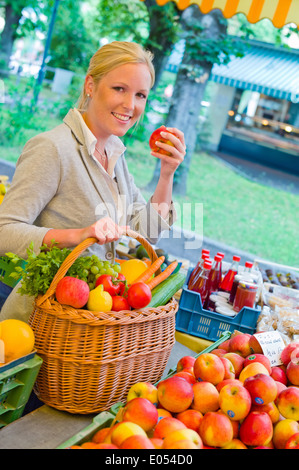 Une jeune femme achète des fruits et des légumes dans un marché hebdomadaire. Aliments frais et sains., eine junge Frau kauft Obst und Gemüse auf e Banque D'Images