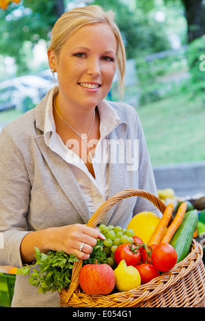 Une jeune femme achète des fruits et des légumes dans un marché hebdomadaire. Aliments frais et sains., eine junge Frau kauft Obst und Gemüse auf e Banque D'Images