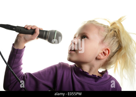 Stock photo de 8 ans aux cheveux blond girl singing into a microphone Banque D'Images