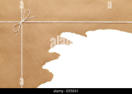 Paquet de papier brun lié avec cordelette bow string ouvert déchiré sur fond blanc Copie espace. Banque D'Images