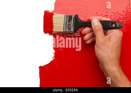 Peinture à la main rouge mur avec Paintbrush Exemplaire blanc Espace. Banque D'Images