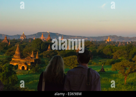 Tourist couple regardant des anciens temples et pagodes de la jungle au lever du soleil, Bagan, Myanmar Banque D'Images