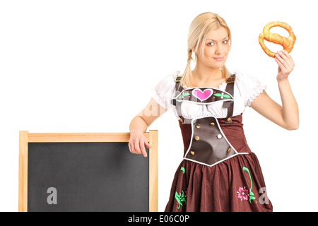 Jeune fille allemande dans un costume traditionnel, tenant un bretzel Banque D'Images