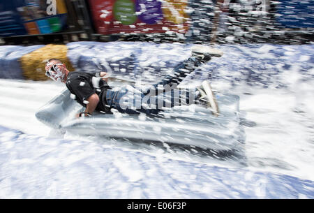 Bristol, Royaume-Uni. 04 mai, 2014. Les gens vers le bas de la vitesse d'un toboggan de 90m érigée sur la rue Park à Bristol. Luke Jerram artiste a organisé l'événement où 300 personnes va dévaler des feuilles de plastique trempé dans du liquide vaisselle et bordée de 400 balles de foin. 4 mai 2014 Crédit : Adam Gasson/Alamy Live News Banque D'Images