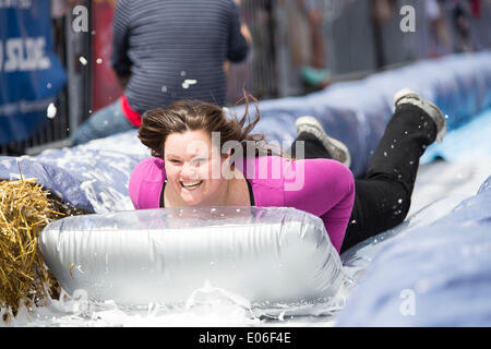 Bristol, Royaume-Uni. 04 mai, 2014. Les gens vers le bas de la vitesse d'un toboggan de 90m érigée sur la rue Park à Bristol. Luke Jerram artiste a organisé l'événement où 300 personnes va dévaler des feuilles de plastique trempé dans du liquide vaisselle et bordée de 400 balles de foin. 4 mai 2014 Crédit : Adam Gasson/Alamy Live News Banque D'Images