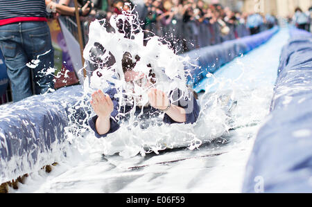 Bristol, Royaume-Uni. 04 mai, 2014. Les gens vers le bas de la vitesse d'un toboggan de 90m érigée sur la rue Park à Bristol. Luke Jerram artiste a organisé l'événement où 300 personnes va dévaler des feuilles de plastique trempé dans du liquide vaisselle et bordée de 400 balles de foin. 4 mai 2014 Crédit : Adam Gasson/Alamy Live News Banque D'Images