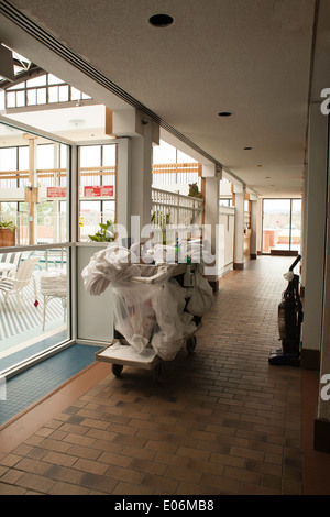 Panier à linge sale et attend à l'extérieur de nettoyage prix dans un hôtel de la Nouvelle Angleterre. Au-delà de la piscine portes en verre. Banque D'Images