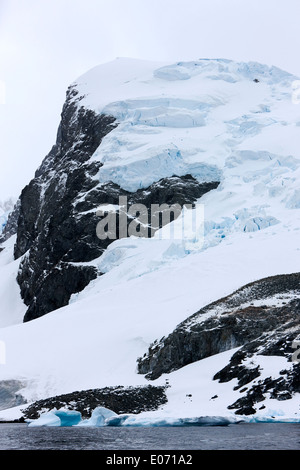 Montagnes couvertes de neige et de glace et glacier avec colonie de pingouins sur l'île cuverville antarctique Banque D'Images