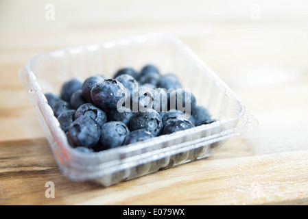 Les bleuets sur table en bois dans un coffret plastique. Banque D'Images