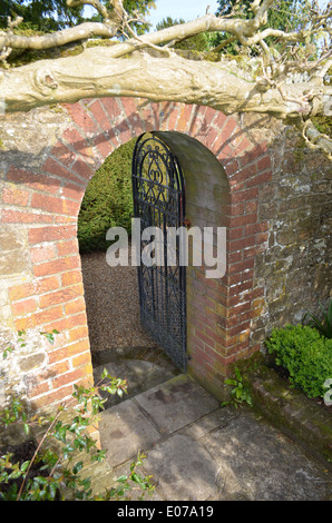 Brique voûté avec porte porte de fer dans un jardin anglais. Banque D'Images