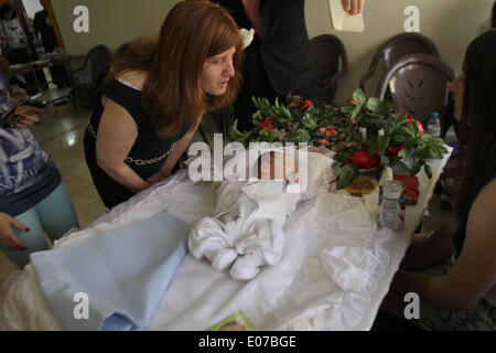 4 mai 2014 - Naplouse, Cisjordanie, territoire palestinien - Femme de la Communauté Samaritaine semble que huit jours au cours d'une circoncision bébé subit une cérémonie de circoncision traditionnelle au sommet du mont Garizim, au-dessus de la ville cisjordanienne de Naplouse, 05 mai 2014. Le rituel de la circoncision est traditionnellement effectuée sur le huitième jour après la naissance d'un bébé de sexe masculin en conformité avec la Torah. Le Samaritain religion descend de l'antique tribus des enfants de Menashe et Efraim, et aujourd'hui la communauté compte environ 700 personnes, dont la moitié vit dans un village de la montagne de Garizim, près de la cité palestinienne Banque D'Images