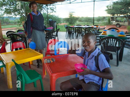 Enfant mangeant à la cantine, de la fondation Africat Okonjima, Namibie Banque D'Images