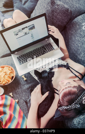 Young woman using laptop aux côtés de son chien de compagnie Banque D'Images